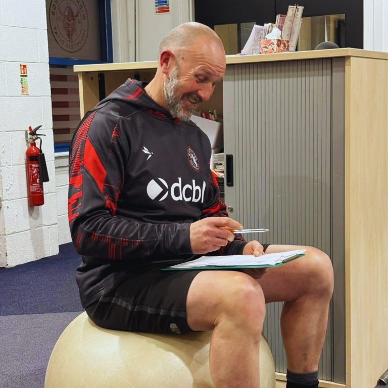 Participant completing reflective worksheet during trauma-informed mental health workshop at DCBL Stadium in Widnes